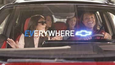 Four women in a car singing happily.