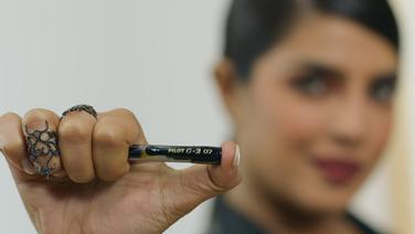 A woman holding a Pilot pen.