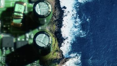 A coastline as seen from above and the coast is a close-up image of a circuitboard.