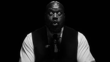 Shaquille O'Neal wearing a suit with spirals in his eyes