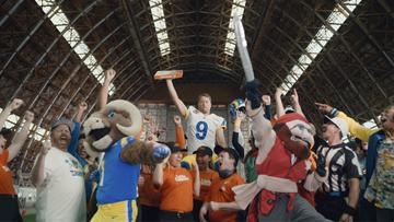A room full of athletes, mascots, sports fans, and Little Caesar's employees cheering.