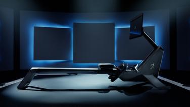 A Peloton rower exercise machine in a dimly lit room.