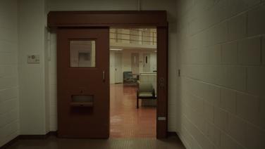The interior of a prison seen through a doorway.